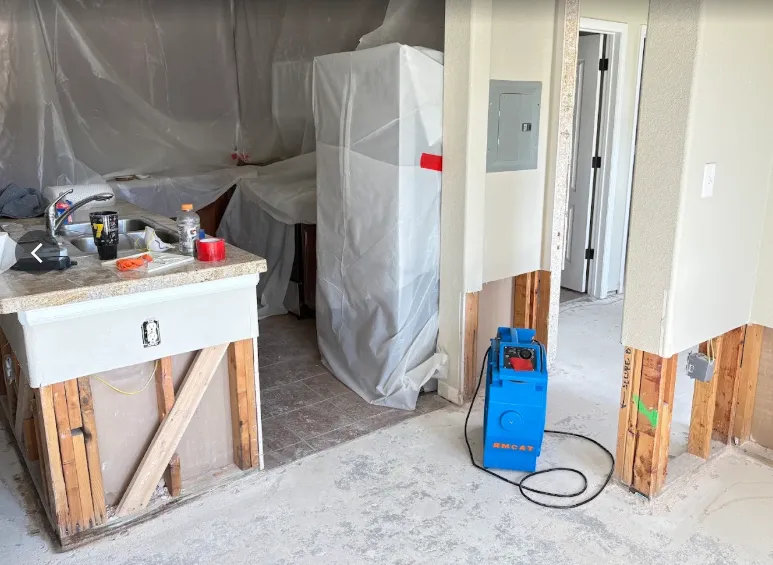 Rocky Mountain crew mid-job: drywall cut, plastic containment and drying equipment in a Grand County kitchen