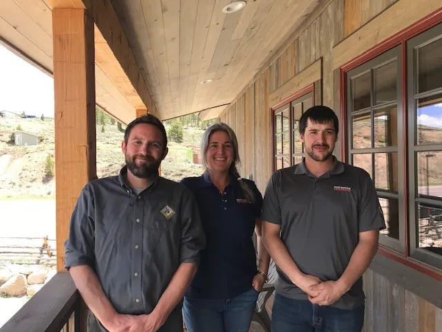 Three Rocky Mountain Catastrophe team members on the porch of the Tabernash office